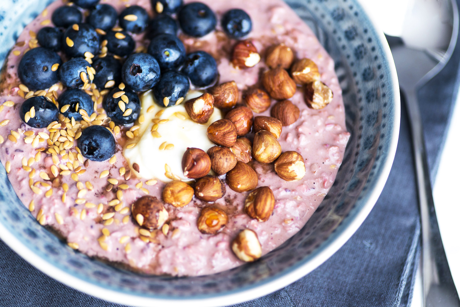 A bowl of bircher muesli with fresh blueberries, yoghurt, hazelnuts and seeds