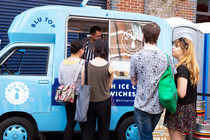 People queuing at a street food van at Druid street market in London People queuing at a street food van at Druid street market in London