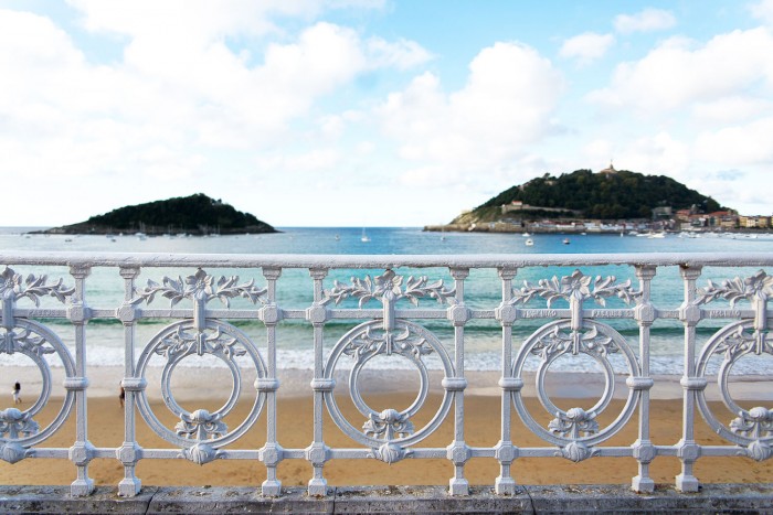A white metal fence in front of Concha beach in San Sebastian Spain