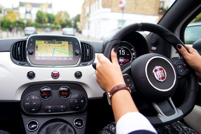 Woman steering the wheel of a Fiat 500 C S Convertible city car Woman steering the wheel of a Fiat 500 C S Convertible city car