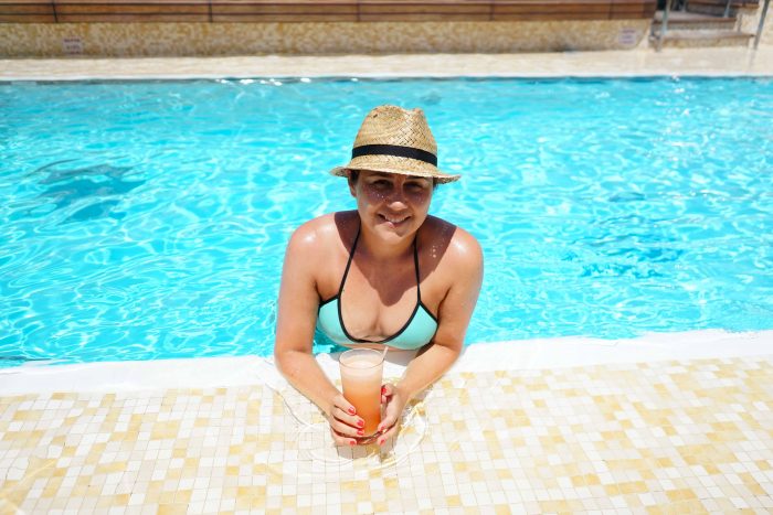 Girl suntanning in the pool with a cocktail | Mondomulia