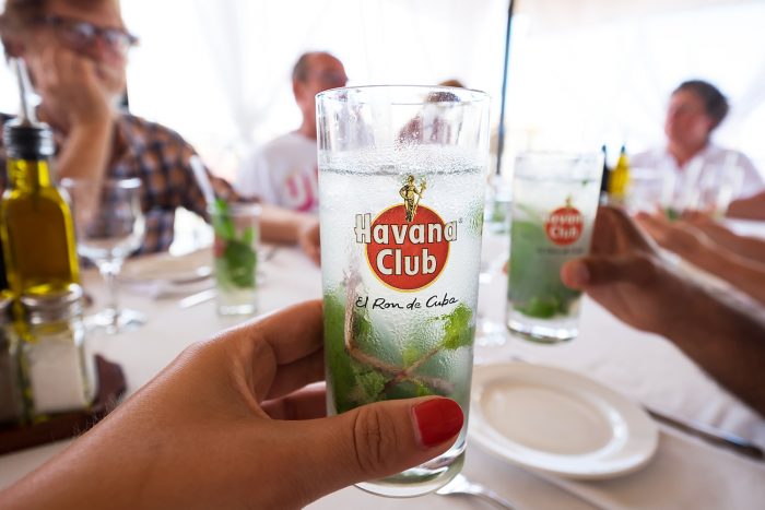 Woman holding a glass of Havana Club mojito cocktail in Cuba Woman holding a glass of Havana Club mojito cocktail in Cuba