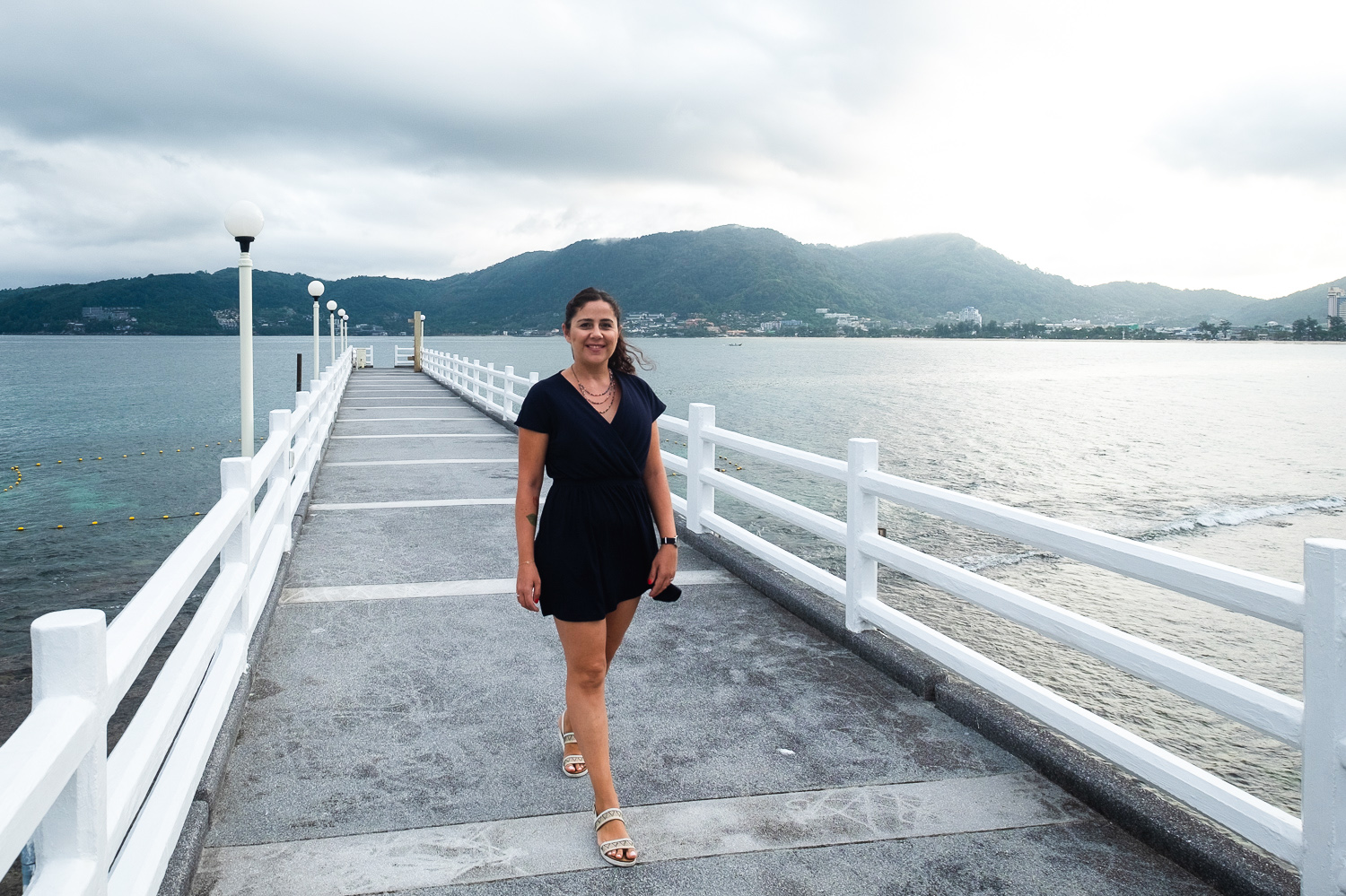 Young girl standing on a jetty in the sea in Phuket, Thailand