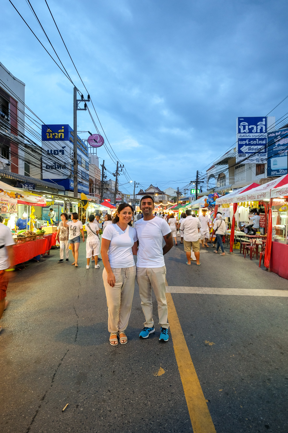 Couple wearing white t-shirts standing in a busy market street in Phuket Thailand Couple wearing white t-shirts standing in a busy market street in Phuket Thailand
