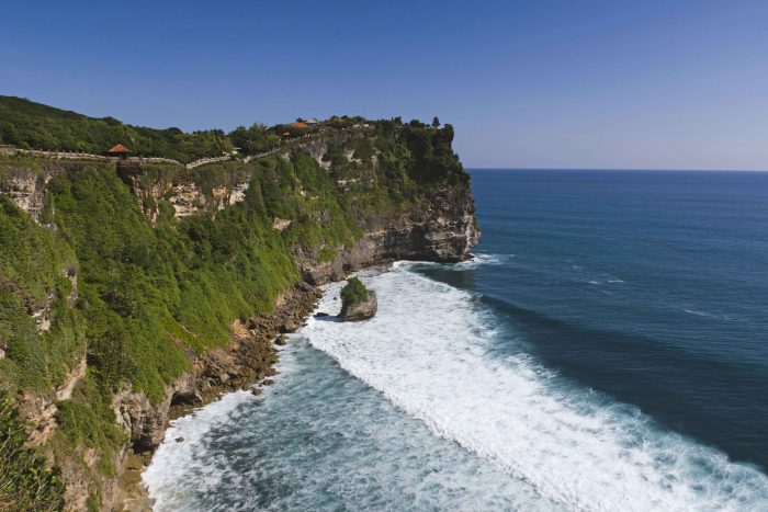 A cliff rock side with the Uluwatu temple site and the Indian ocean in Bali Indonesia A cliff rock side with the Uluwatu temple site and the Indian ocean in Bali Indonesia
