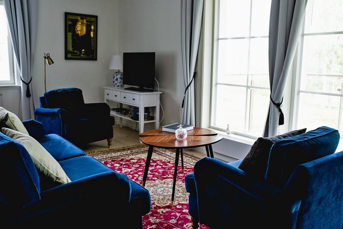 A cosy living room with blue sofa and red carpet in Sweden A cosy living room with blue sofa and red carpet in Sweden