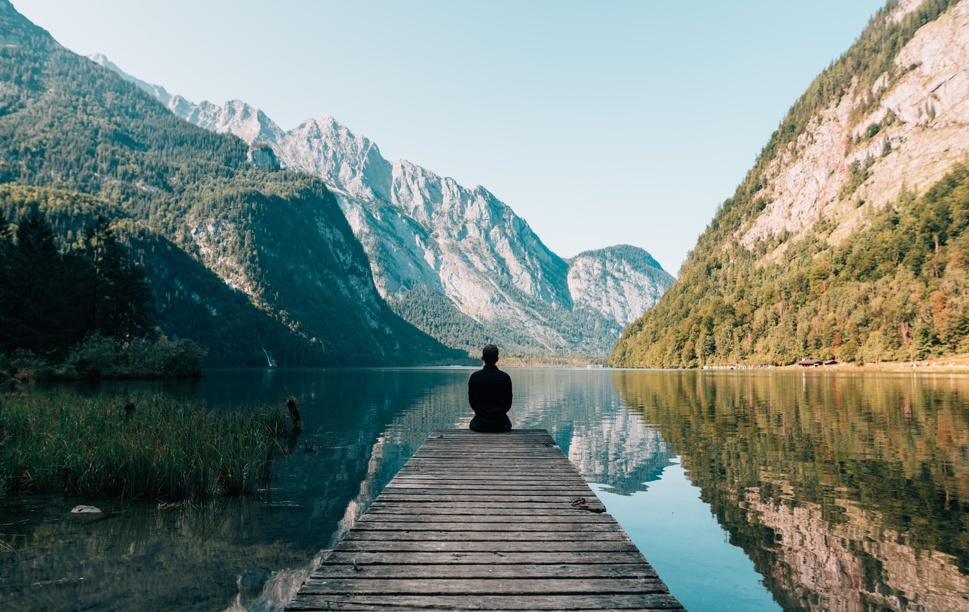 Man sitting on gray dock in Königssee, Schönau am Königssee, Germany