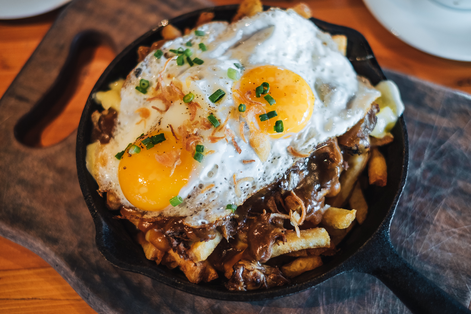 Canadian poutine is a dish of french fries and cheese curds topped with a brown gravy.