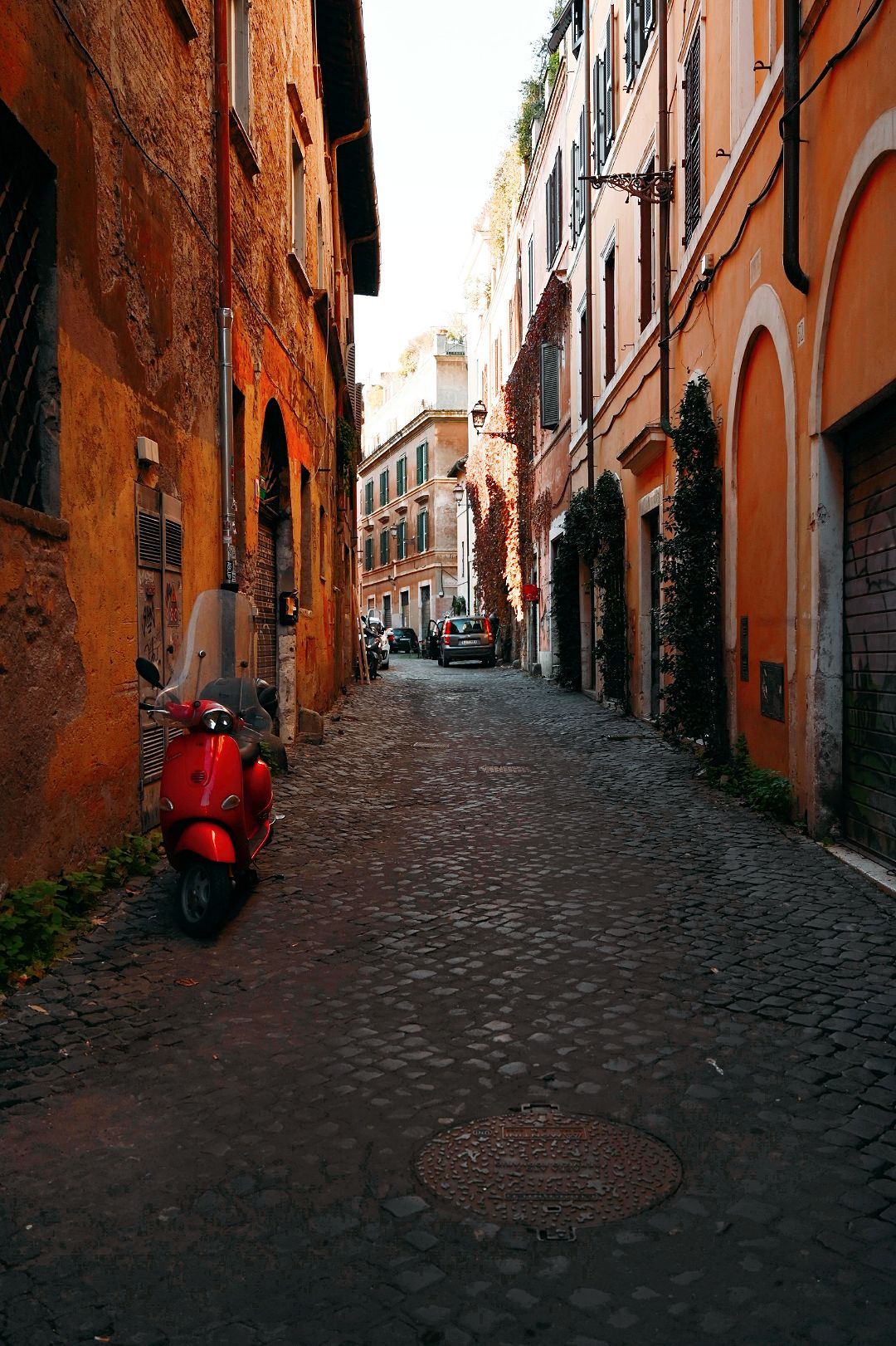 Red scooter in Trastevere neighbourhood in Rome Italy
