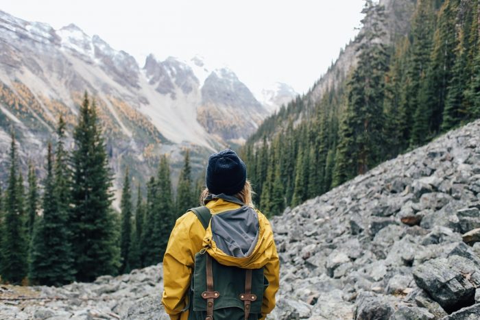 Mountains travel, girl with yellow jacket and backpack