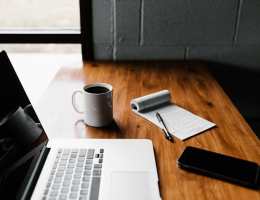 Macbook Pro on Brown Wooden Table with coffee and smartphone