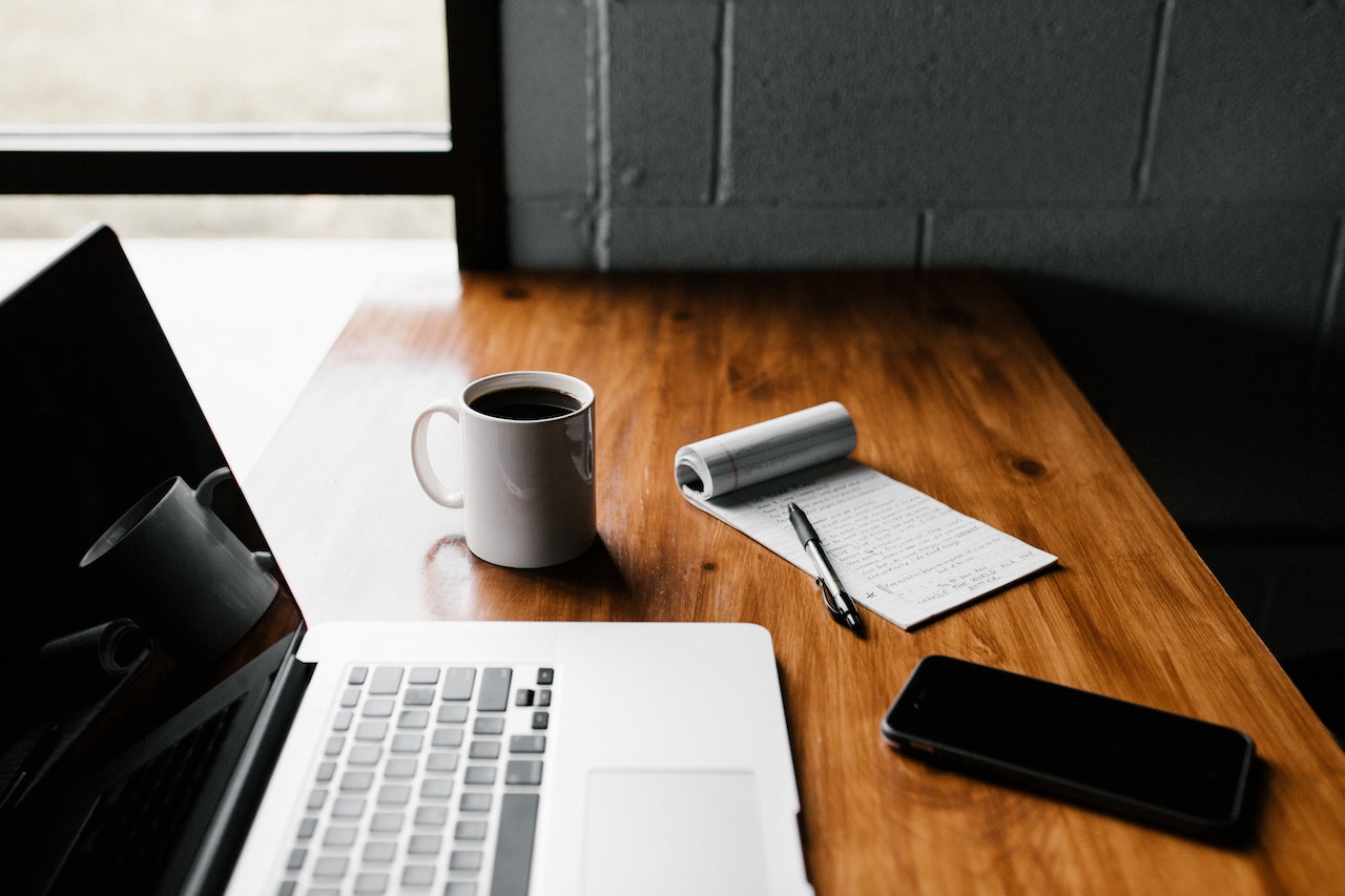 Macbook Pro on Brown Wooden Table with coffee and smartphone