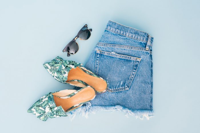 Summer holiday items: jeans shorts, sandals and sunglasses