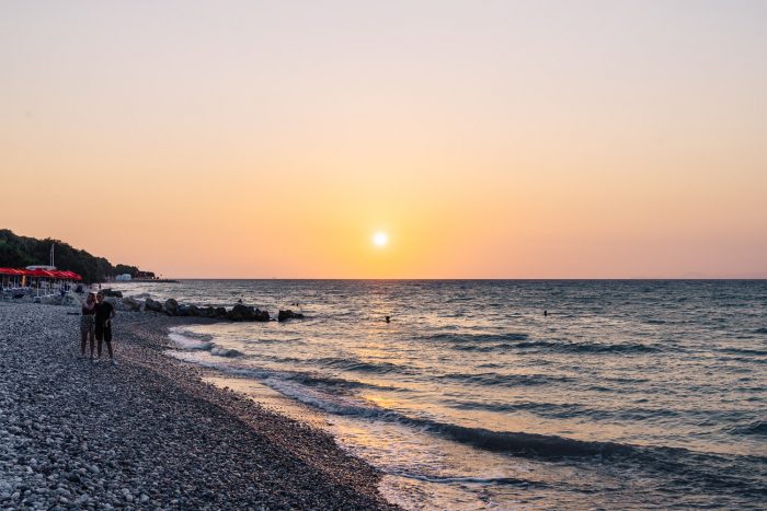 Watching the sunset on the beach in Ialysos, Rhodes island, Greece Watching the sunset on the beach in Ialysos, Rhodes island, Greece