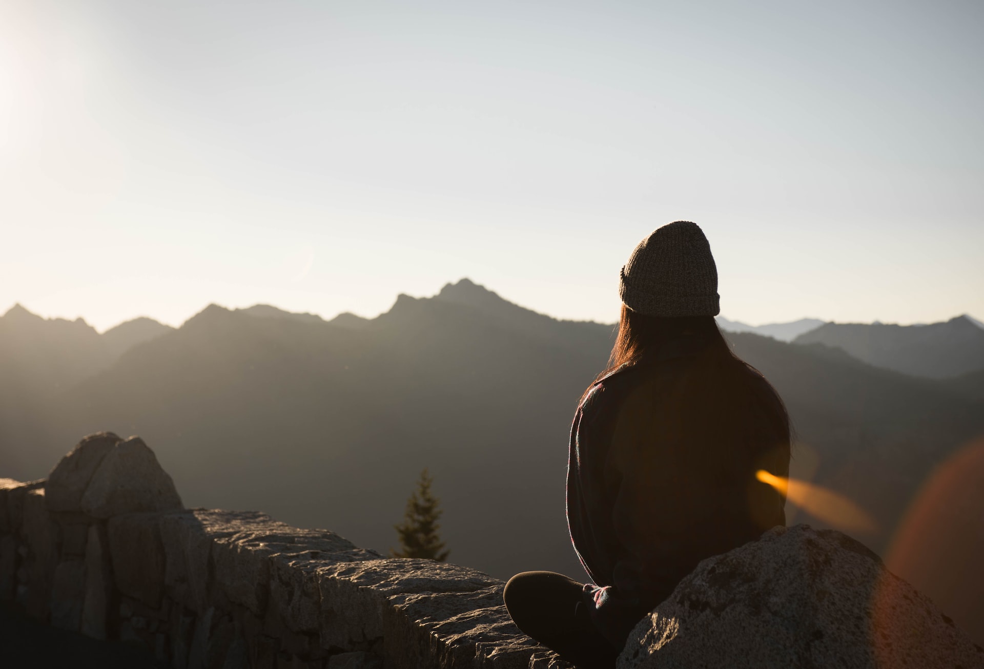 girl wearing knit cap facing mountain at sunrise girl wearing knit cap facing mountain at sunrise