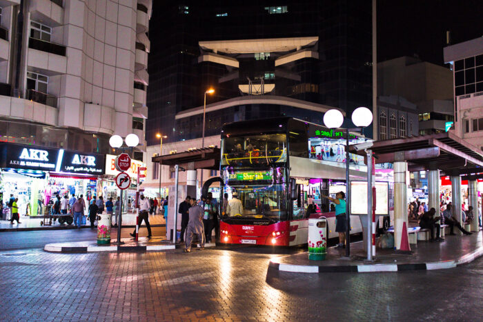 A coach bus at a bus stop in old Dubai at night