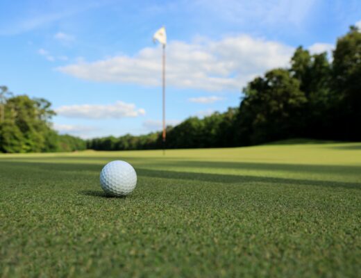 a golf ball sitting on top of a green field