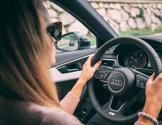 woman driving Audi car with hands on steering wheel