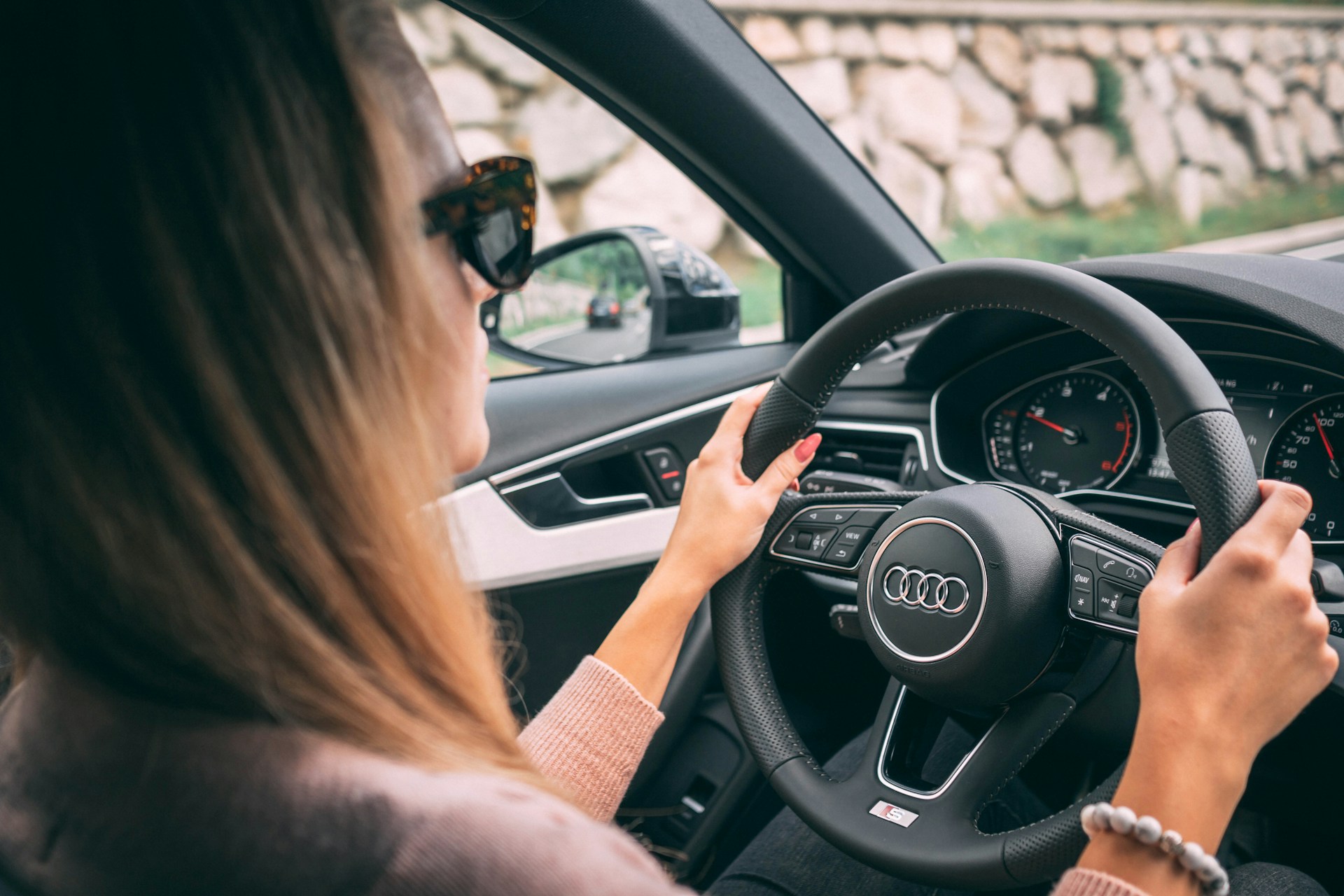 woman driving Audi car with hands on steering wheel