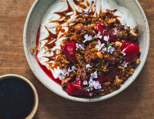 Yoghurt and granola and fruit bowl for breakfast with a cup of black coffee