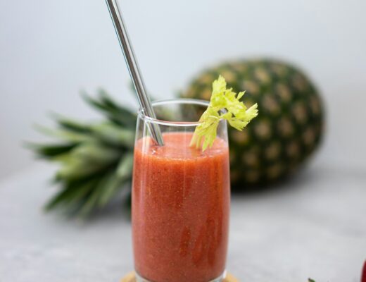 Strawberry and pineapple smoothie in a glass with metal straw