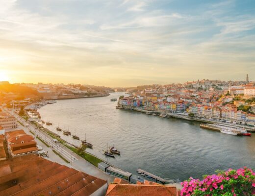 Porto lies on the hilly north bank of the Douro River. City buildings during sunset