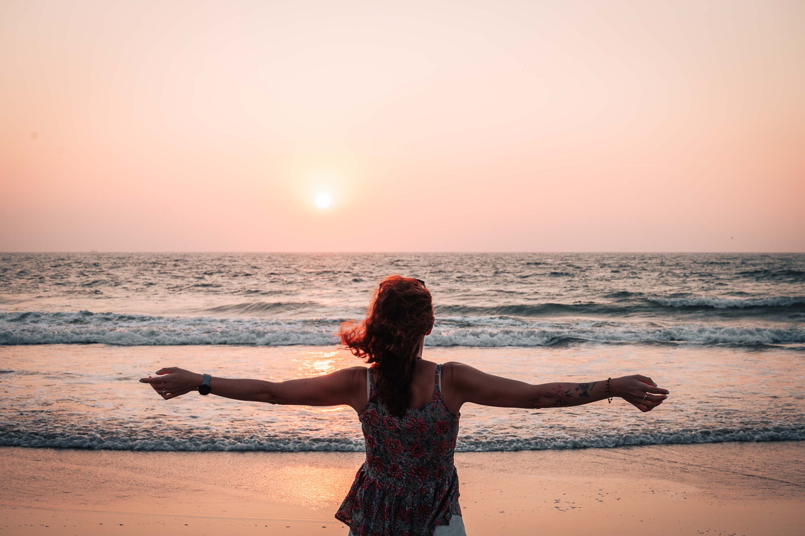 Young girl watching the sunset on a beach