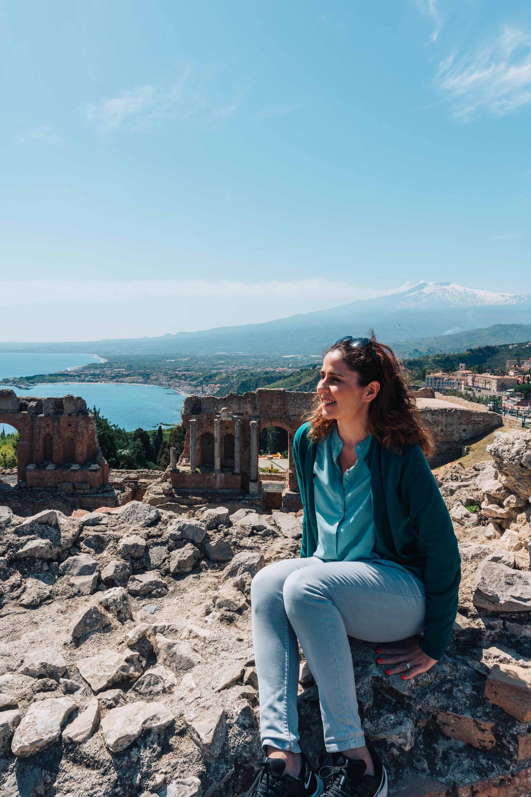 Young woman sitting in front of the Greek amphitheatre in Taormina, Sicily