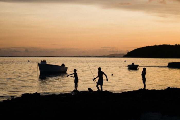 a group of people standing on a beach in front of the sea in Mauritius a group of people standing on a beach in front of the sea in Mauritius