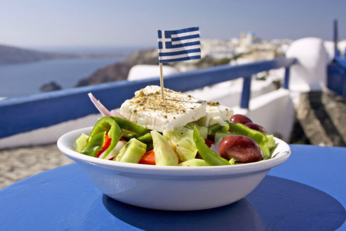 A dish of Greek salad on a blue table by the sea A dish of Greek salad on a blue table by the sea