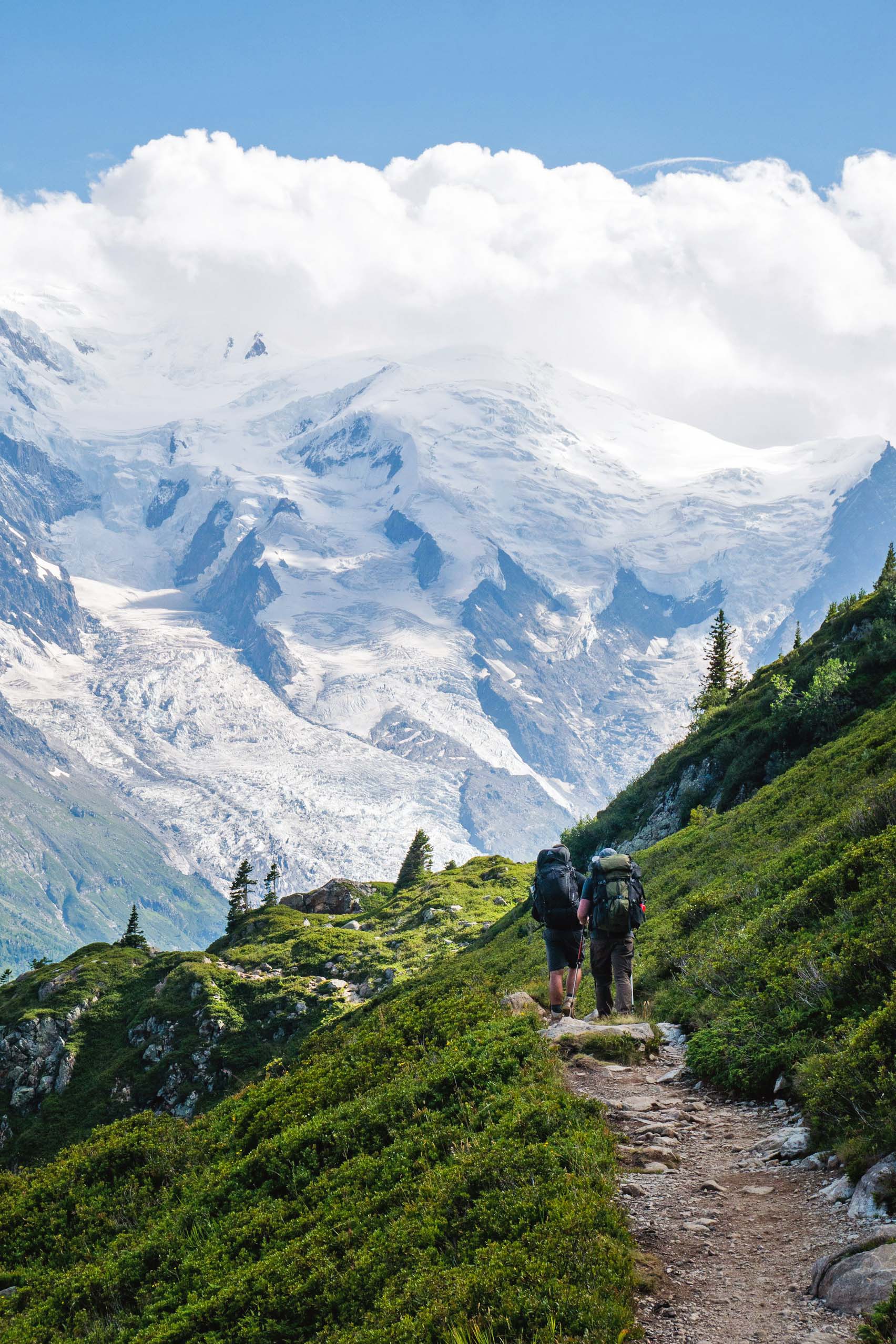 Mountain hikers in the French Alps with snowy peaks and clouds in the sky Mountain hikers in the French Alps with snowy peaks and clouds in the sky