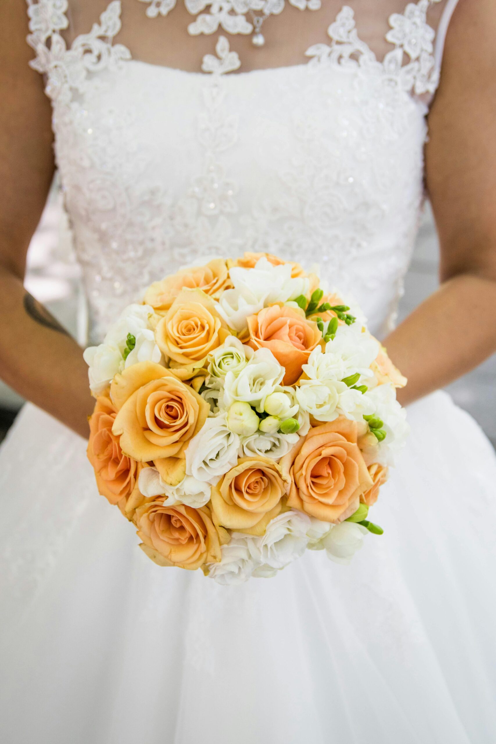 Bride in a white wedding dress holding yellow flowers Bride in a white wedding dress holding yellow flower bouquet