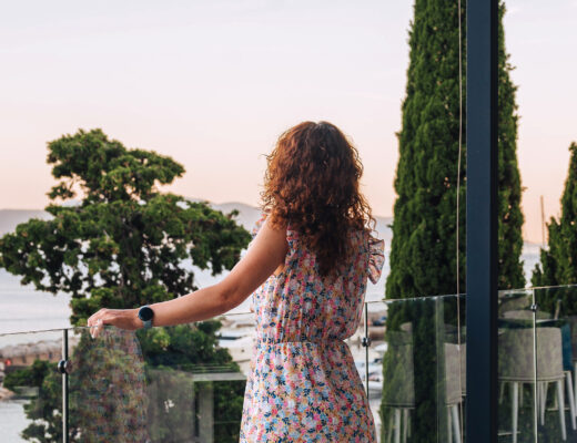 Woman standing on a terrace looking at the Adriatic Sea at sunset in Croatia