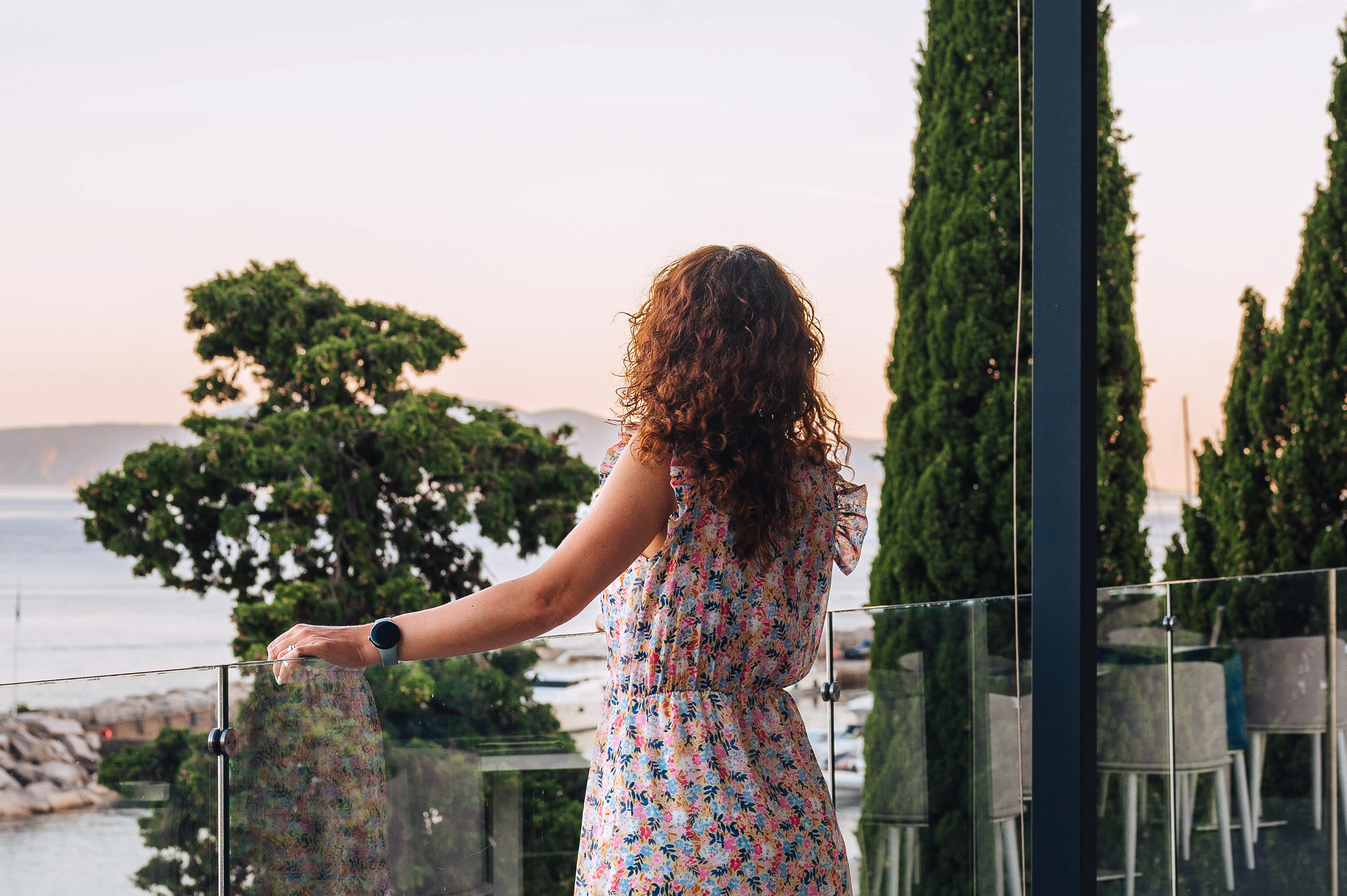 Woman standing on a terrace looking at the Adriatic Sea at sunset in Croatia