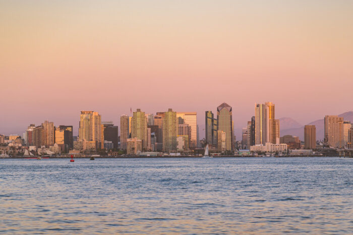 Sandy Diego skyline at sunset seen from the ocean Sandy Diego skyline at sunset seen from the ocean