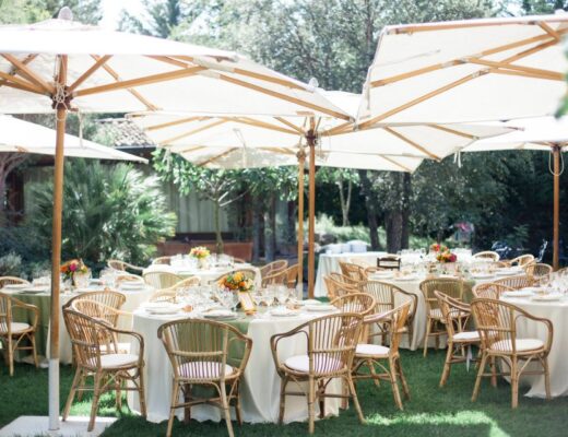 Tables with white tablecloths set up in a garden for an outdoor summer wedding in Italy