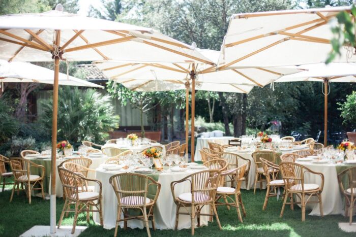 Tables with white tablecloths set up in a garden for an outdoor summer wedding in Italy Tables with white tablecloths set up in a garden for an outdoor summer wedding in Italy