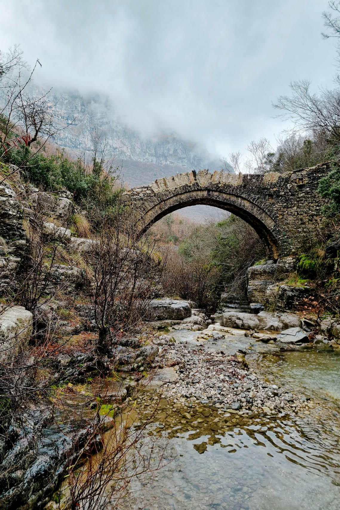 ancient stone bridge over river in national park in greece