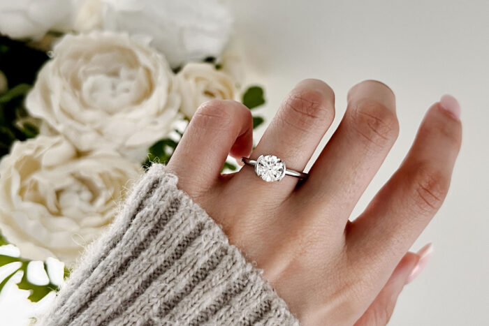 a woman's hand with a white gold and diamond engagement ring