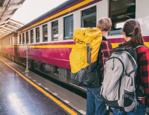 young people with backpacks at the train station waiting for train