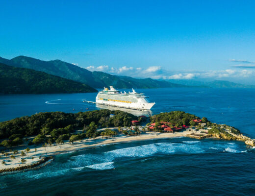 a cruise ship docked at a small island photo