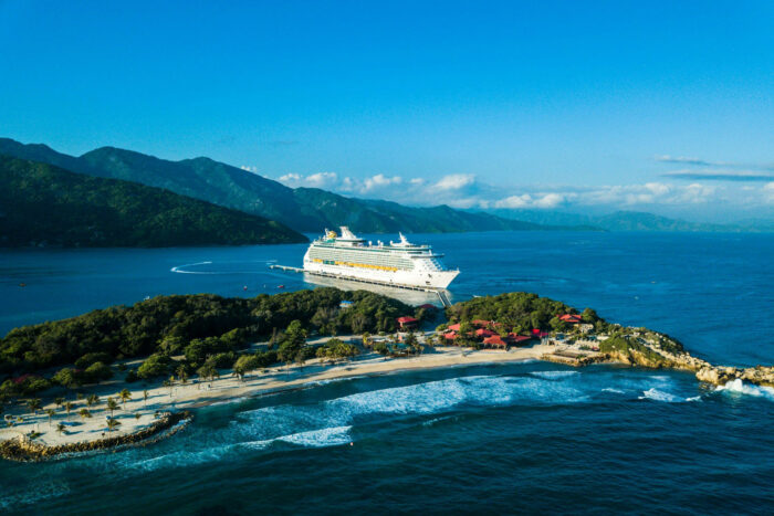 a cruise ship docked at a small island photo