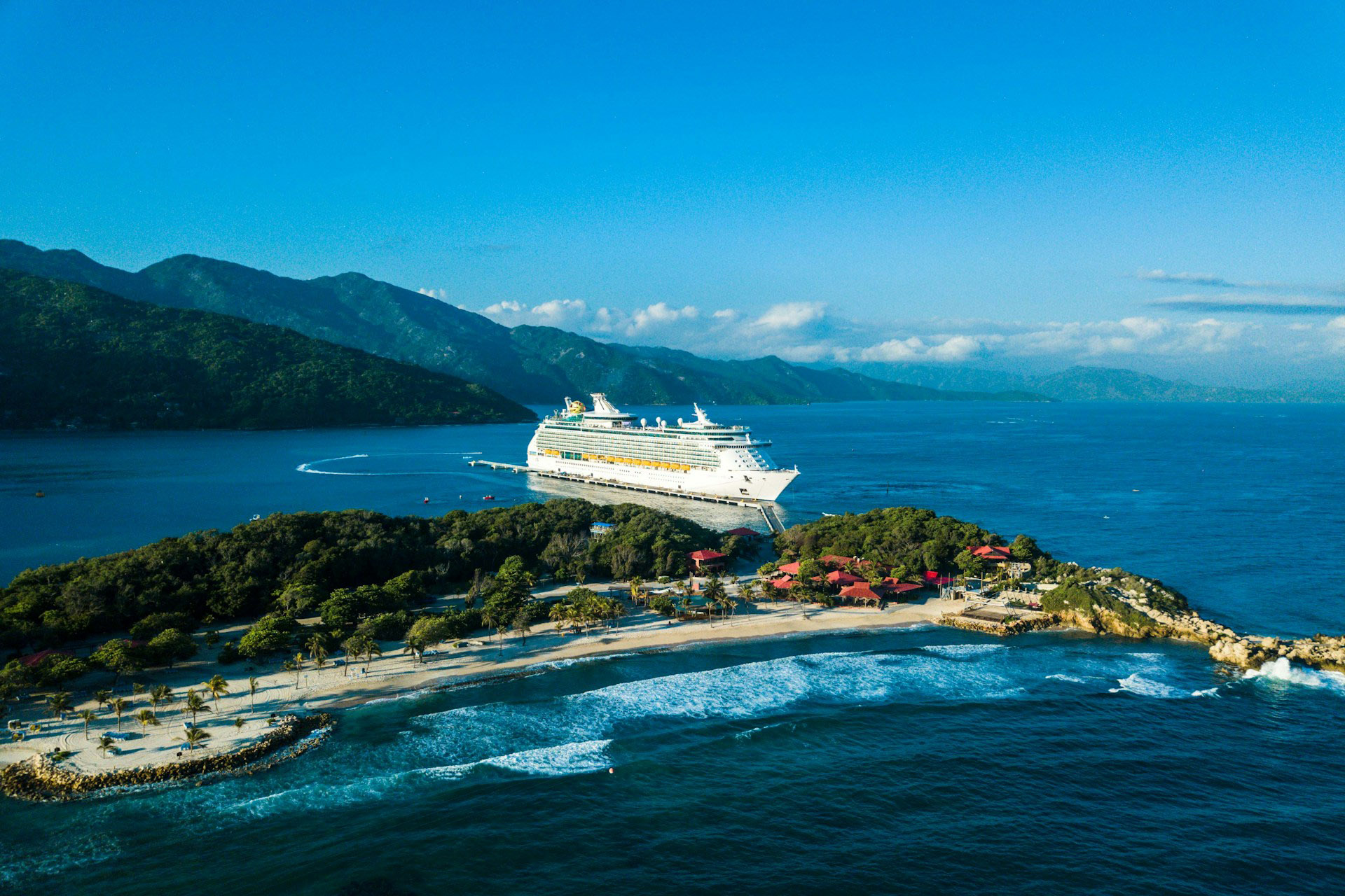 a cruise ship docked at a small island photo
