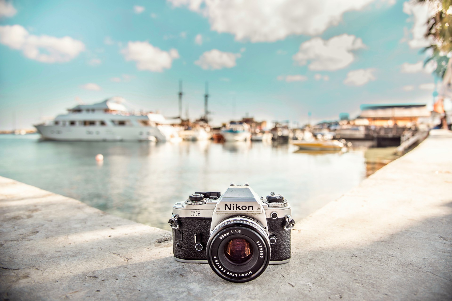 vintage Nikon camera near boats and sea in daytime photo