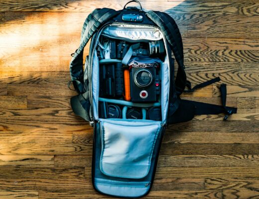 flat lat of backpack with dSLR camera on wooden floor