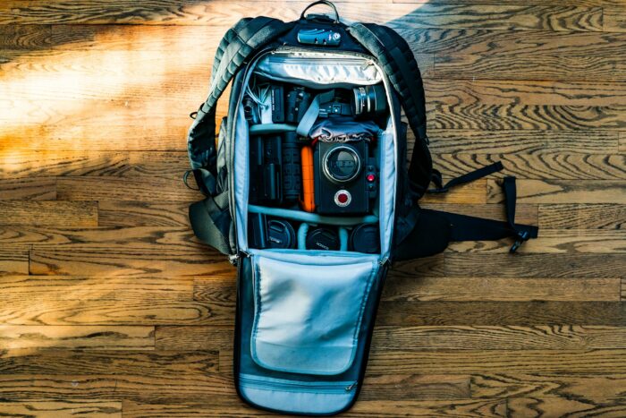 flat lat of backpack with dSLR camera on wooden floor