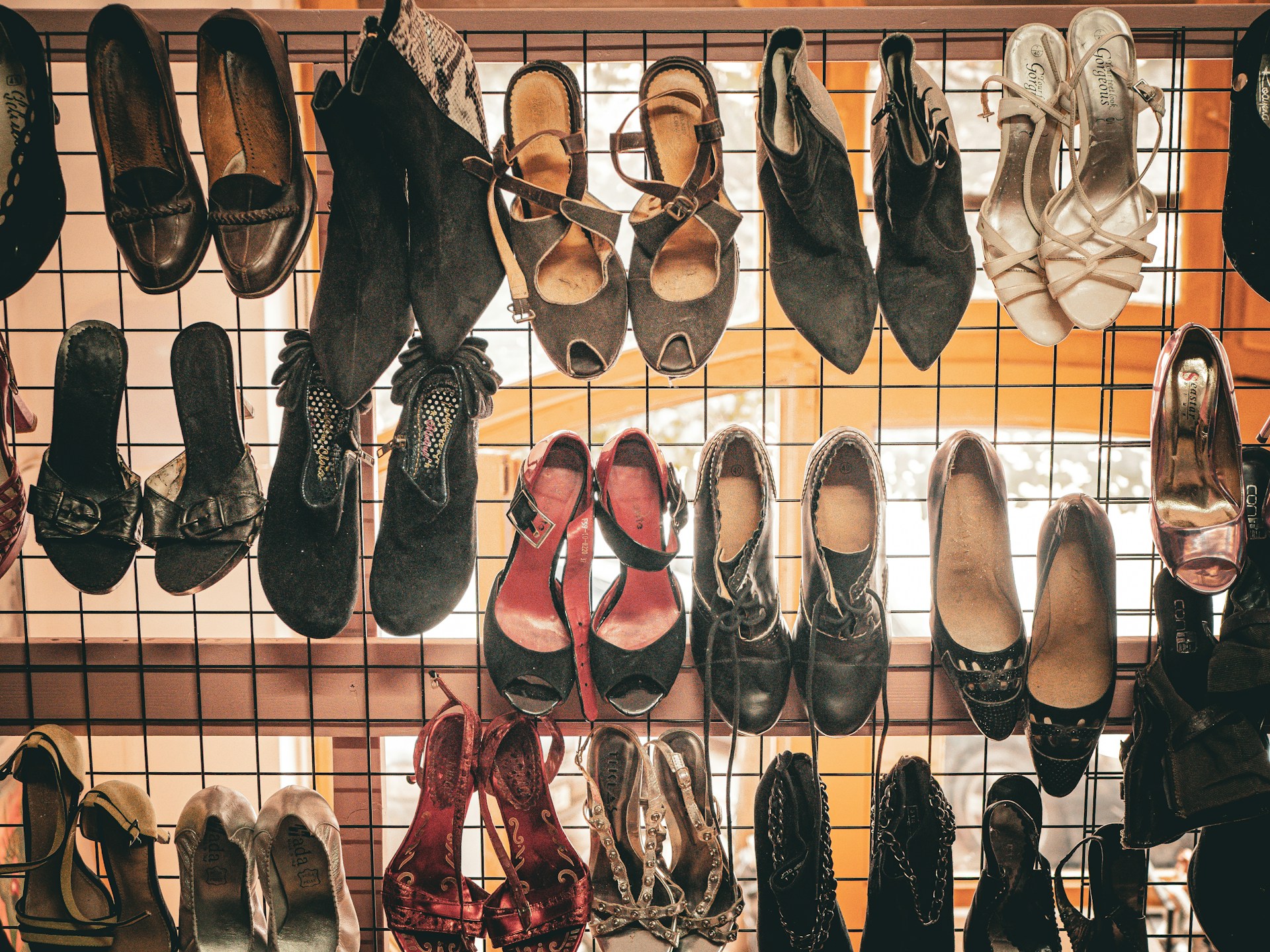 assortment of vintage shoes displayed on a rack assortment of vintage shoes displayed on a rack