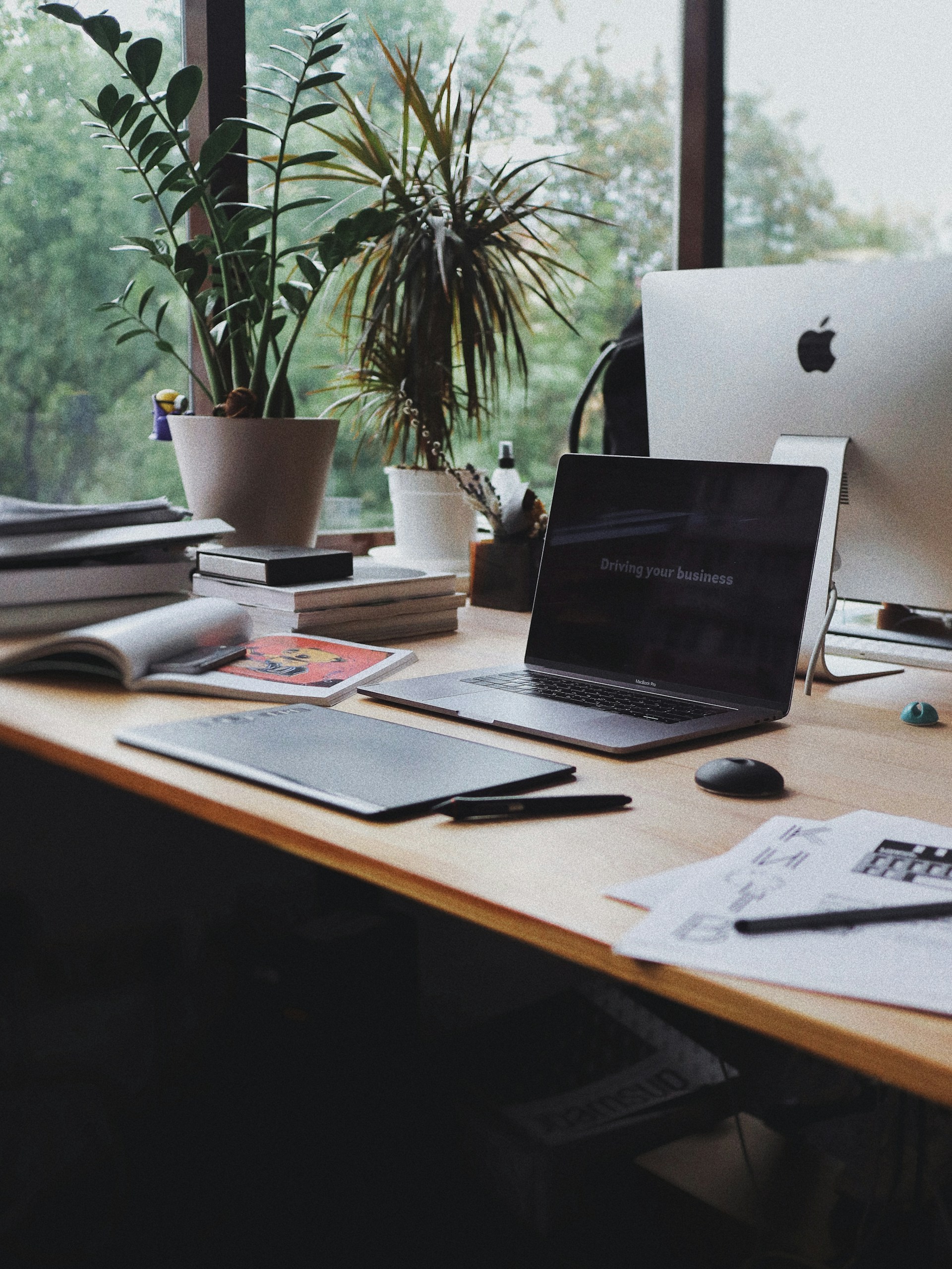 Laptop on a busy desk in an office business designer Laptop on a busy desk in an office business designer