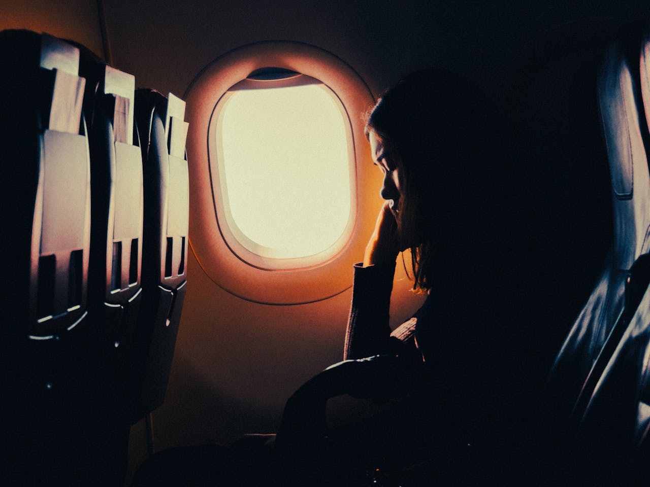 woman sleeping in an airplane near the window