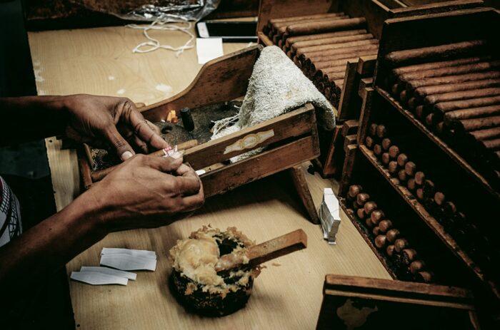 hands rolling cigars in a factory in havana, cuba hands rolling cigars in a factory in havana, cuba